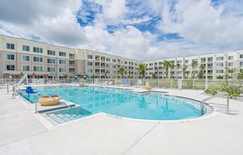 a large swimming pool with an apartment building in the background